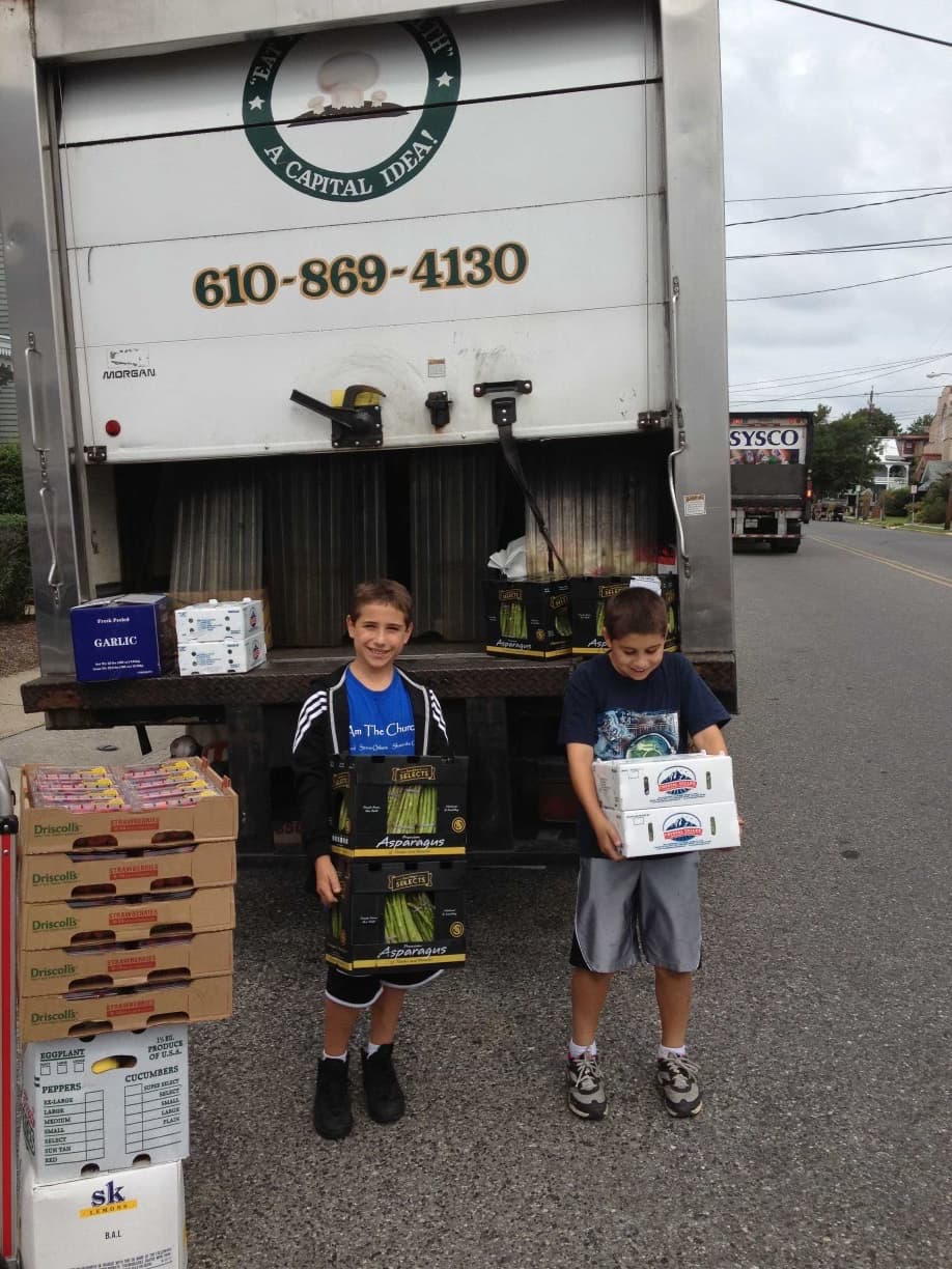 Joe Starkey on the left with his brother unloading produce from a Capital Mushroom & Specialties truck